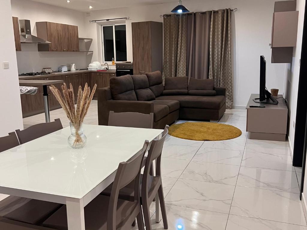 uma sala de estar com uma mesa branca e um sofá em 3 bedroom apartment in Marsascala em Marsaskala