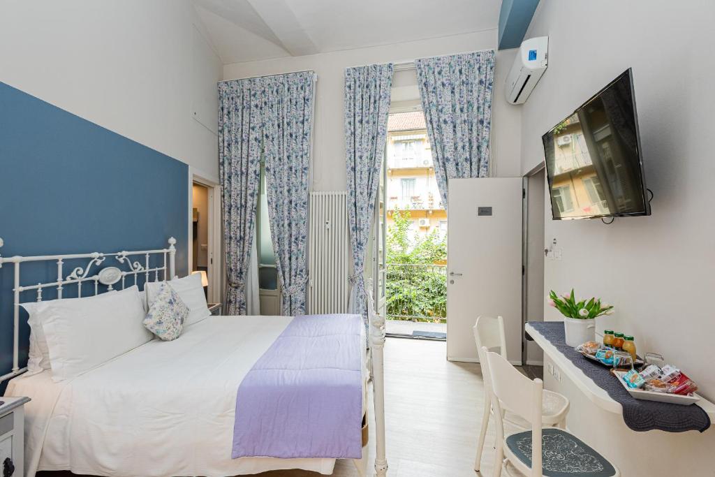 - une chambre avec un lit, une télévision et une fenêtre dans l'établissement Maison Rêve Torino Centro, à Turin