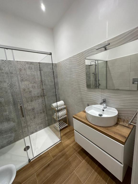 een badkamer met een wastafel en een glazen douche bij Appartamento Aretusa di G&G in Siracusa