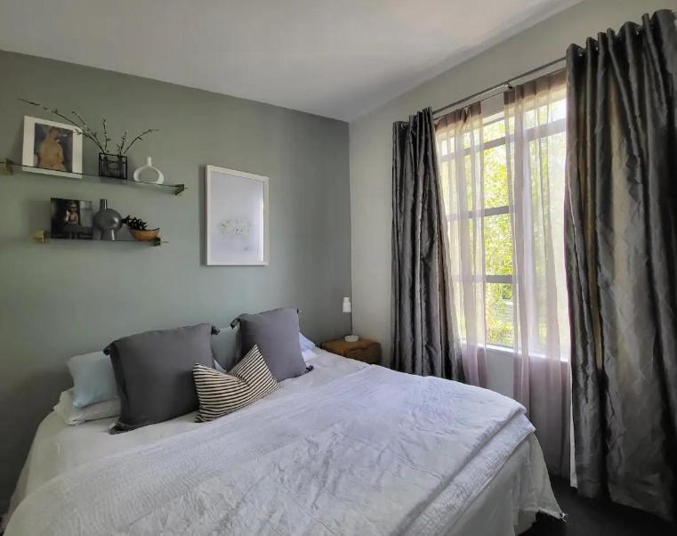 um quarto com uma cama grande e uma janela em Artist Photographers Home Studio em Auckland
