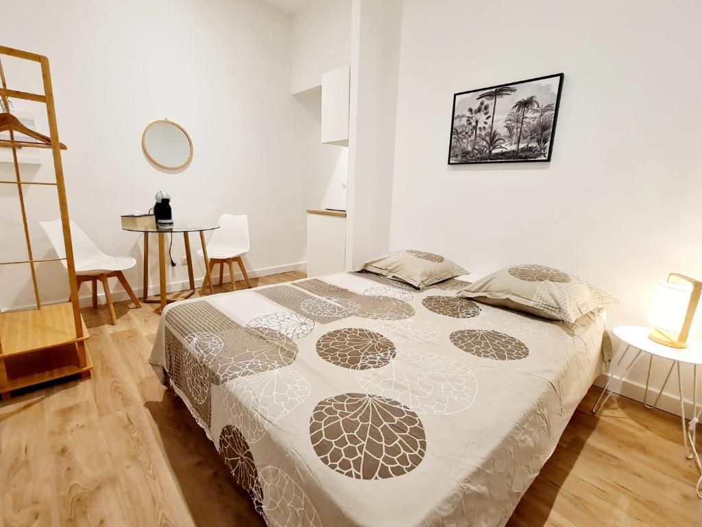 een slaapkamer met een bed en een tafel en stoelen bij Le Marty 2 Studio in Carcassonne