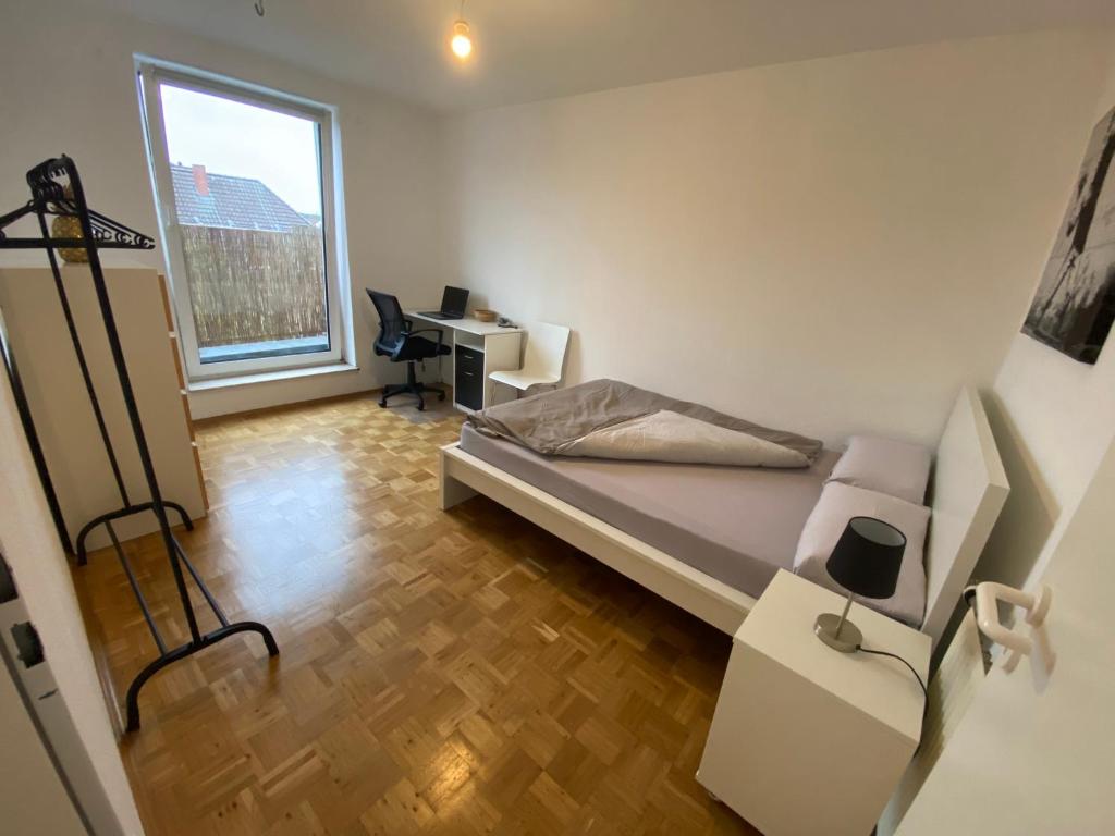 a bedroom with a bed and a desk and a window at Modernes Apartment in zentraler Lage in Münster