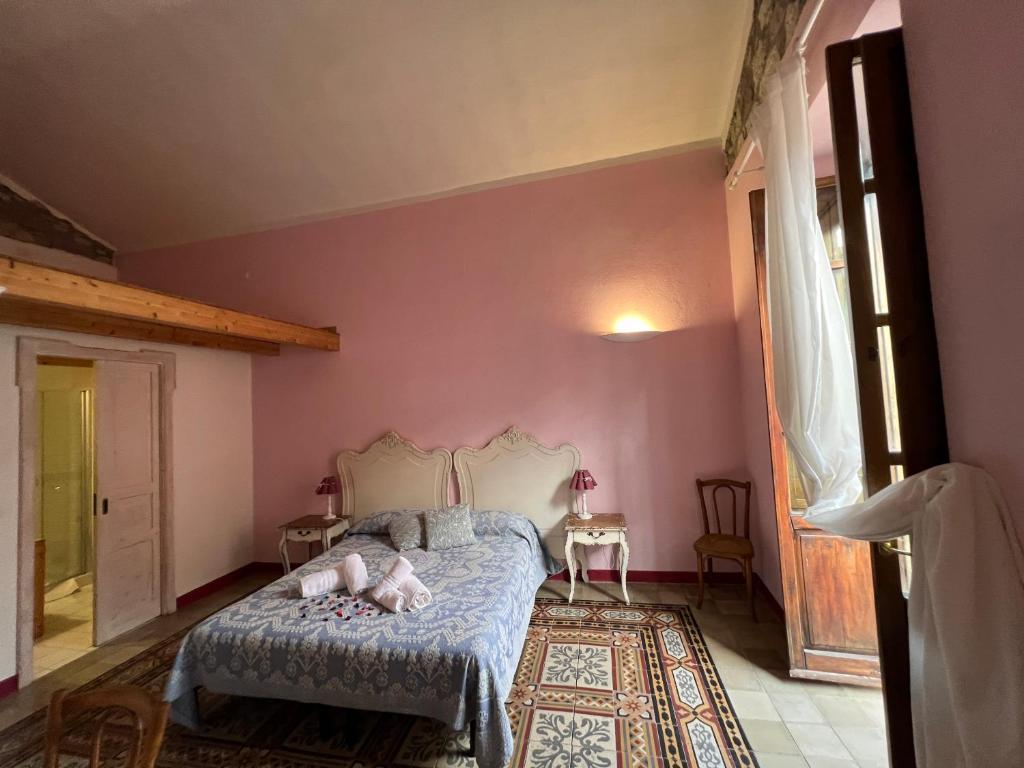 1 dormitorio con paredes rosas y 1 cama en una habitación en Corso 41 en Bosa