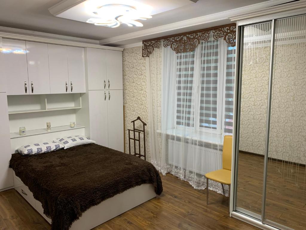 um quarto com uma cama e uma grande janela em APARTMENT PREMIUM VIP em Berdychiv