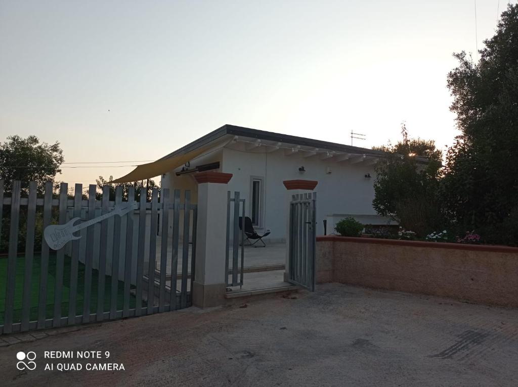 une maison blanche avec un portail et une clôture dans l'établissement Montescotano House, à Villa Castelli
