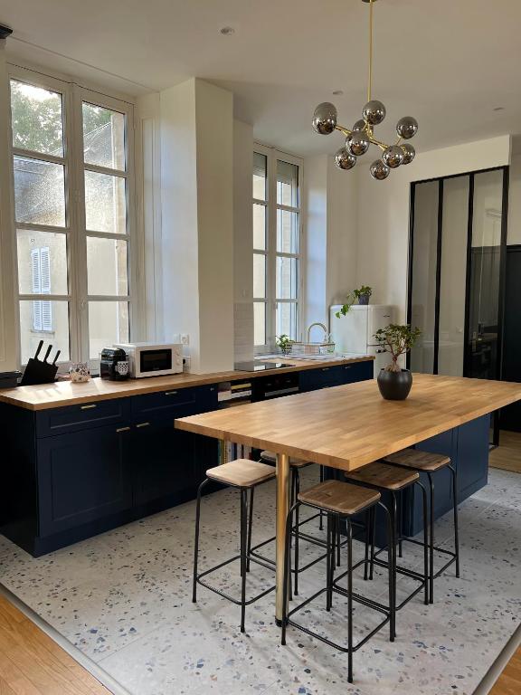 een keuken met een houten tafel en een aantal stoelen bij Bright Apt 70m2 in Bayeux historic center w Pkg in Bayeux