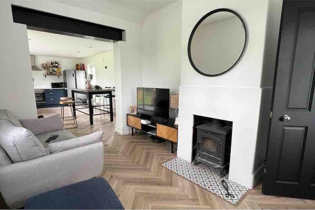 a living room with a mirror and a fireplace at Ballybur Cottage in Kilkenny