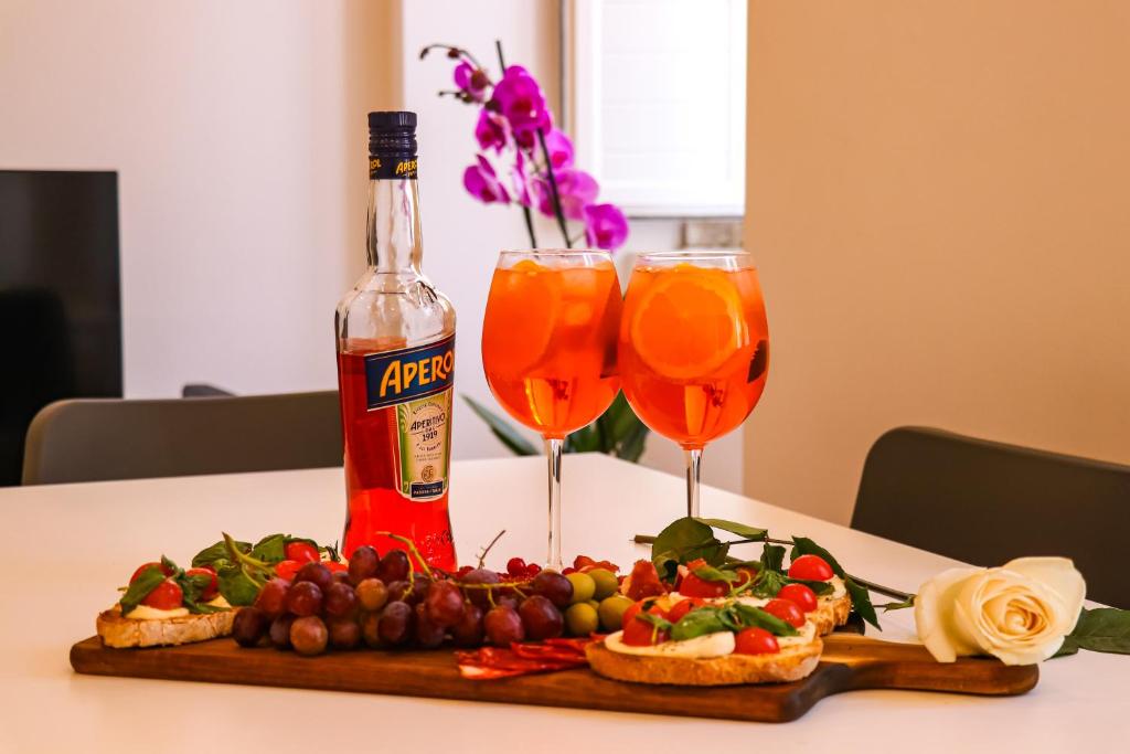 een tafel met twee glazen wijn en een dienblad met eten bij Golden Place - Cacilhas in Almada