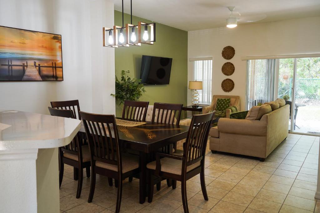 a dining room and living room with a table and chairs at Enchanting Escape 3 Bedroom Minutes from Disney! in Kissimmee