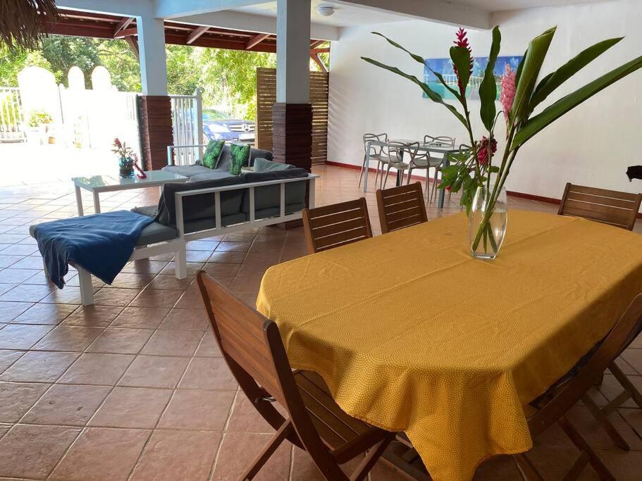 une table jaune avec un vase de fleurs sur elle dans l'établissement Douceur des Hauteurs bas de villa, piscine privée, à Sainte-Luce