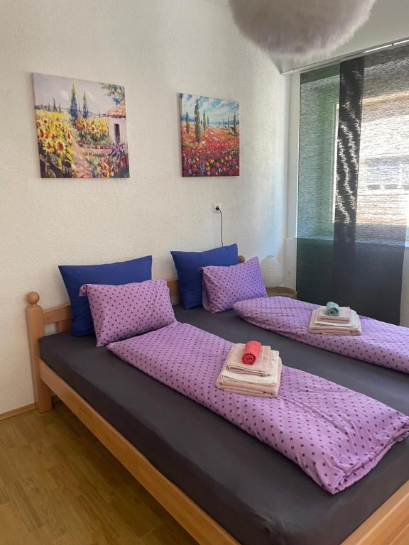 a bedroom with two beds with purple cushions at Anna in Livno