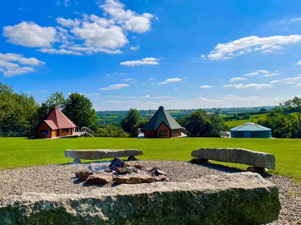 a fire pit in a field with houses in the background at Exmoor Lodge (Oak Tree Lane) in Okehampton