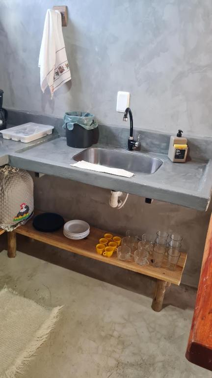 a kitchen counter with a sink and a shelf under it at Chale Flat pousada do vini in Corumbau