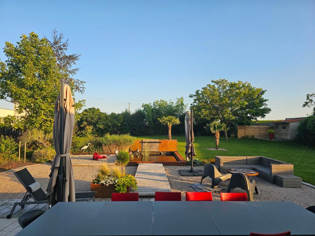 a patio with a table and chairs and umbrellas at Chez Marianne in Wailly