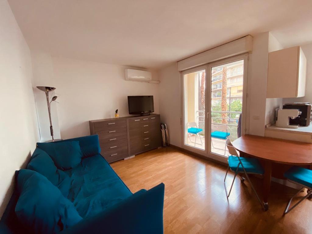 a living room with a blue couch and a table at Pretty flat 2mn from beach in Nice