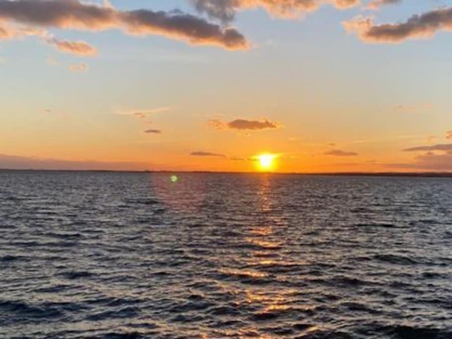 a sunset over the ocean with the sun setting at La perle de Sète Maison bord de l étang Animaux bienvenus Sur demande in Sète