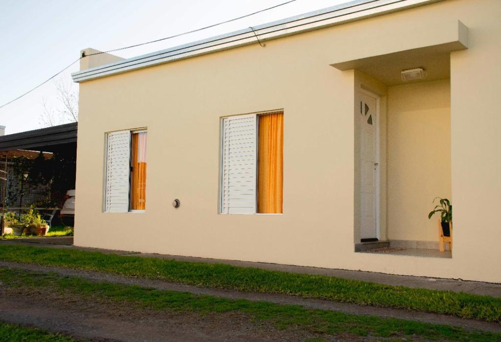 a white house with windows and a driveway at LOS GURISES in Villa Elisa