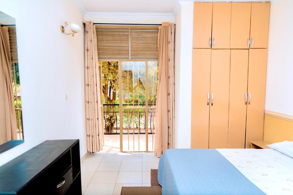 a bedroom with a bed and a sliding glass door at Cosy Hidden Gem in Kigali
