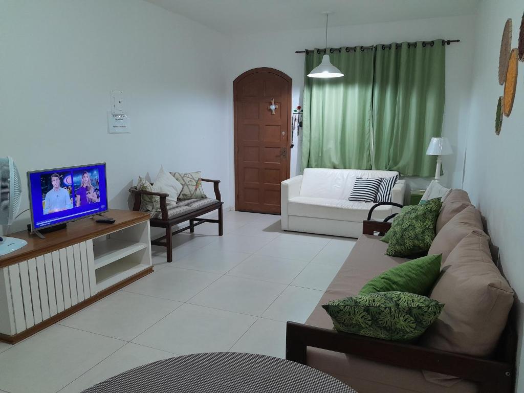 a living room with a couch and a tv at Casa agradável in Cabo Frio
