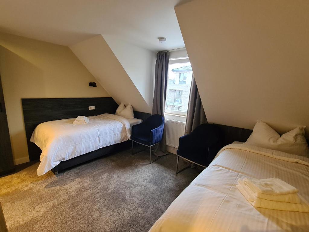 a hotel room with two beds and a window at 3 Monkeys Hotel in Steinfurt