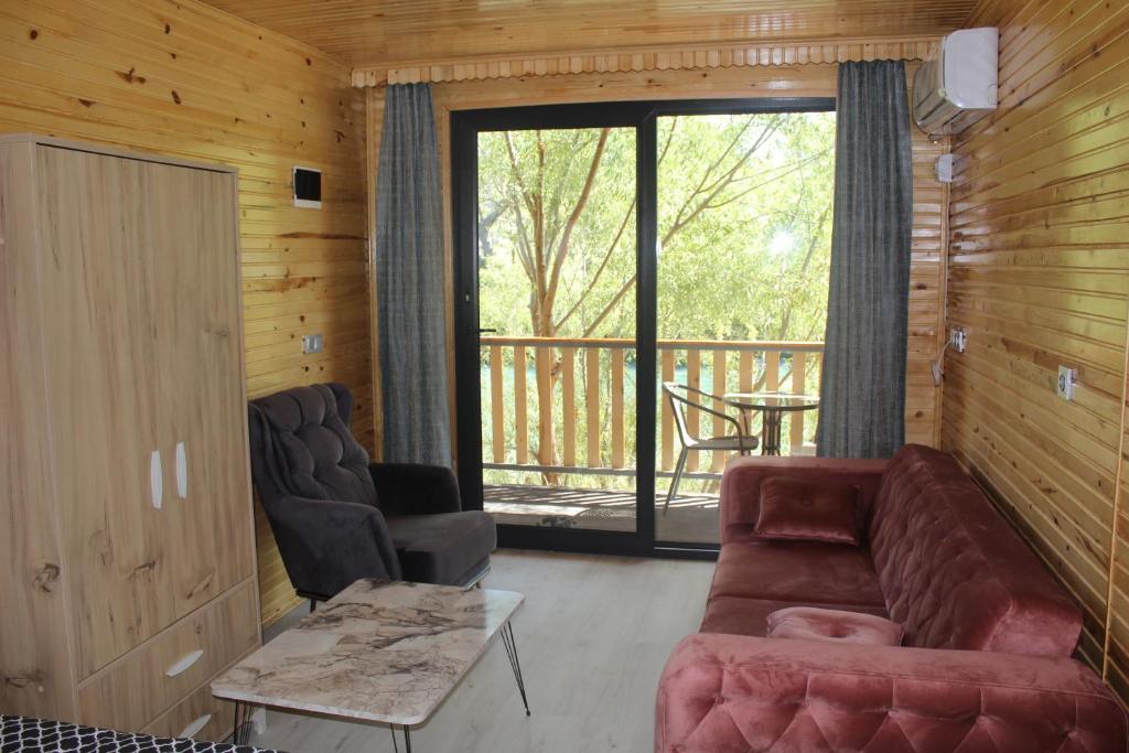 a living room with a couch and a balcony at Rio Adventures Rafting Köprülü Kanyon Konaklama in Karabük