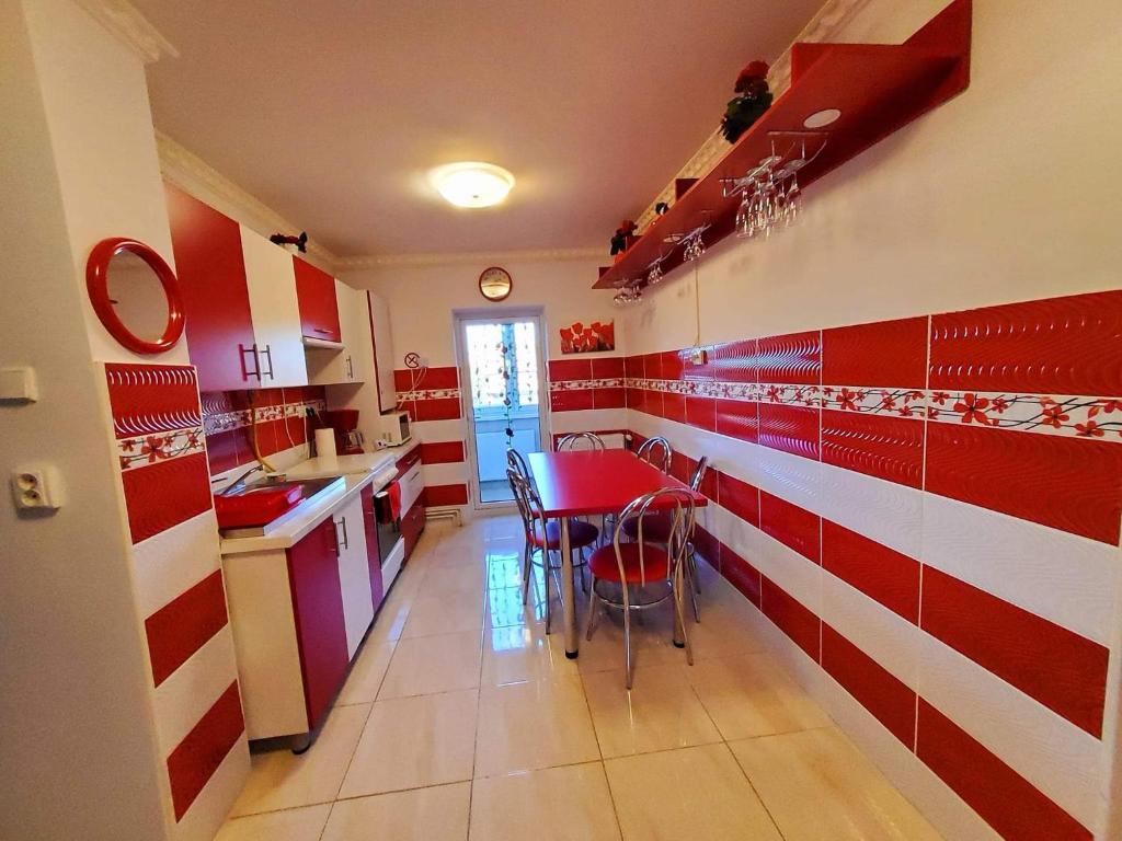 een keuken met rode en witte strepen aan de muur bij Apartman Lux in Covasna