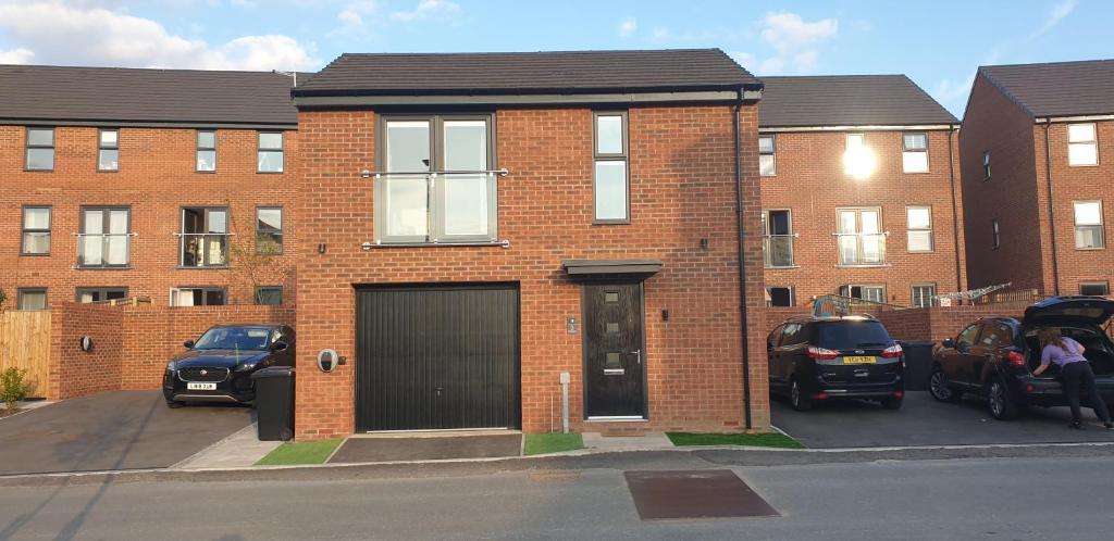 a brick building with cars parked in front of it at 5 Star Luxury Small Cosy House with Lake View in Doncaster