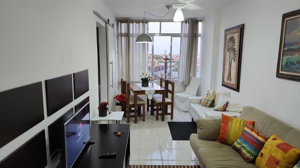 uma sala de estar com um sofá e uma mesa em Apezinho da Soltony em Peruibe em Peruíbe
