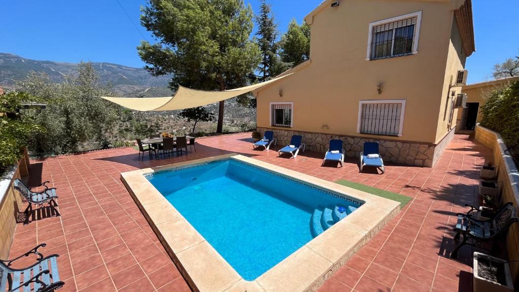 a swimming pool in front of a house at Villa Paloma in Árchez