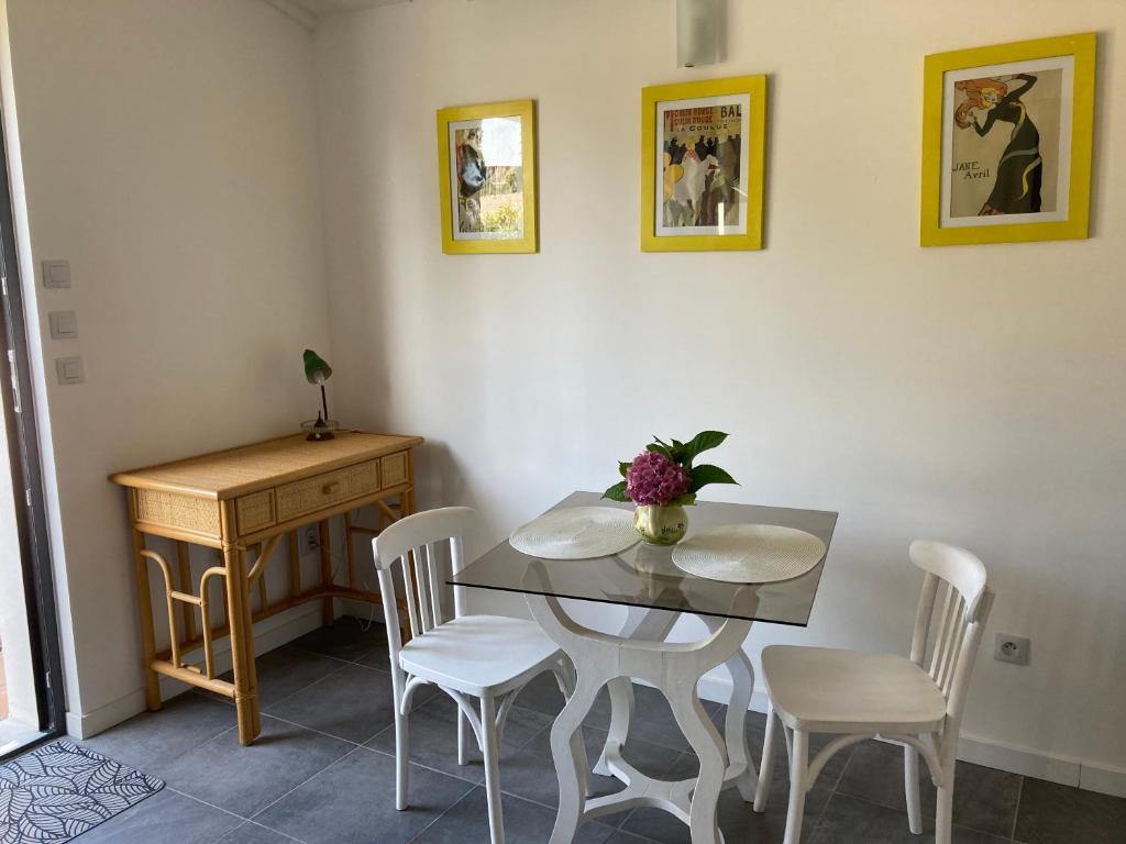 uma sala de jantar com mesa e cadeiras e uma secretária em Le Cube em Marans