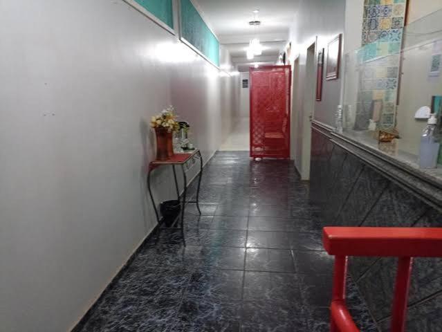 a hallway with a red door and a red bench at Hotel Canal Hum in Brasilia