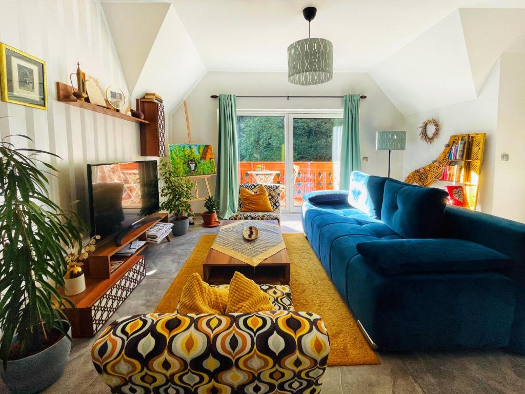 een woonkamer met een blauwe bank en een tafel bij NiceHead spacious home between Maribor and Celje in Loče pri Poljčanah