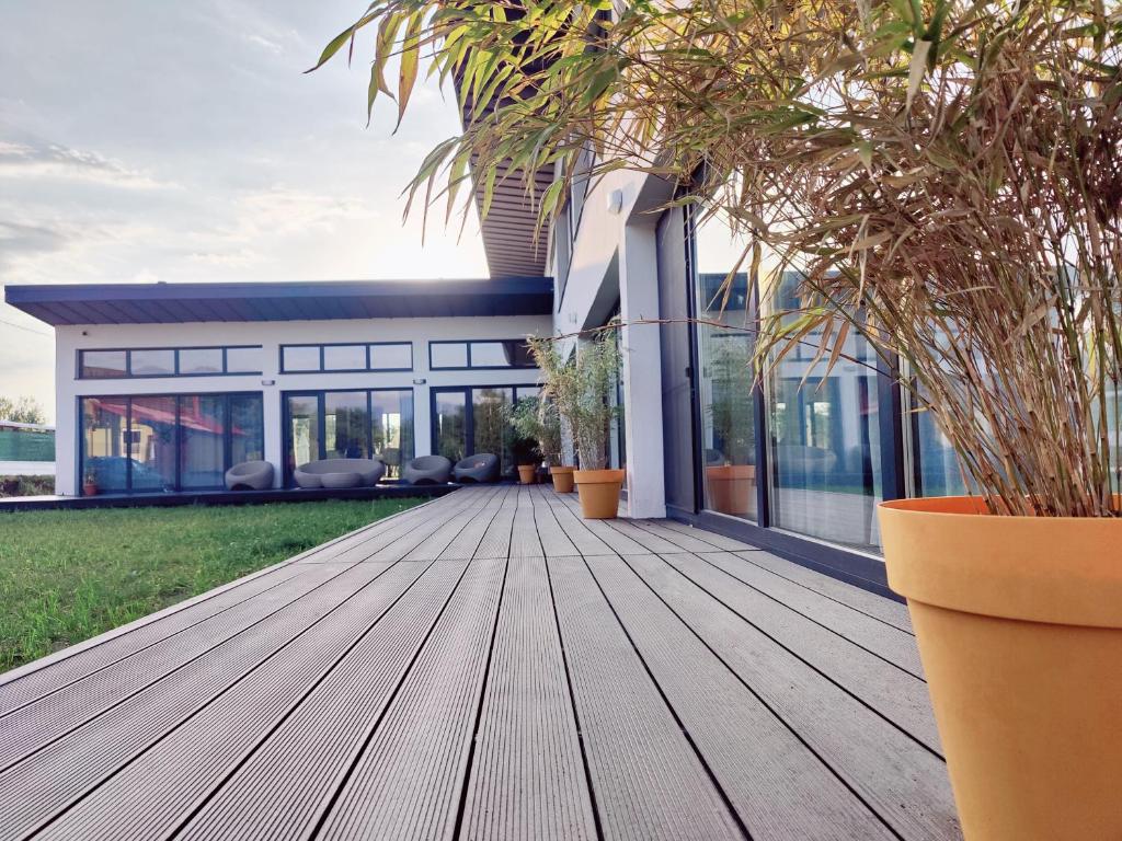 une terrasse en bois devant une maison ornée de plantes dans l'établissement JAI GIRIDHARI, à Avrig