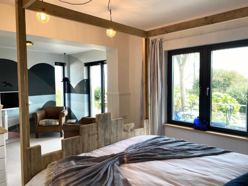 a bedroom with a large bed with a large window at Mevagissey Boutique Flatlet with sea and countryside views in Mevagissey
