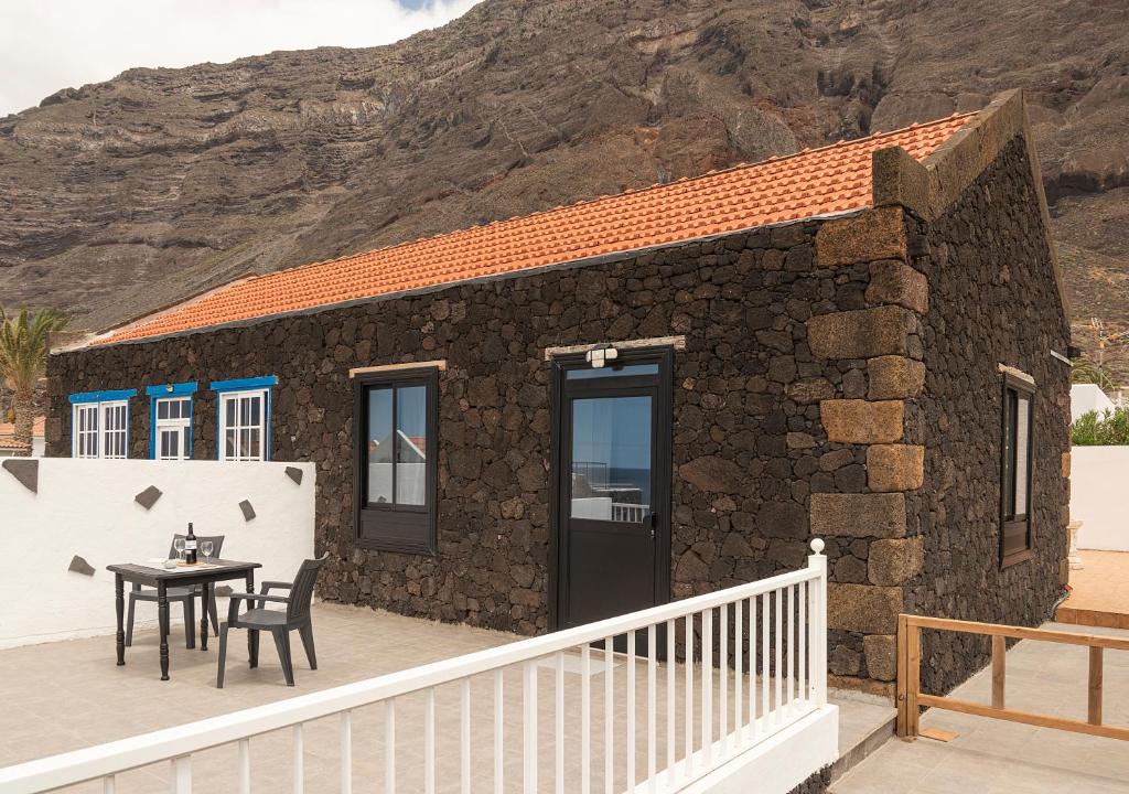 Las Puntas的住宿－Irama Suite，石头房子,甲板上配有桌椅