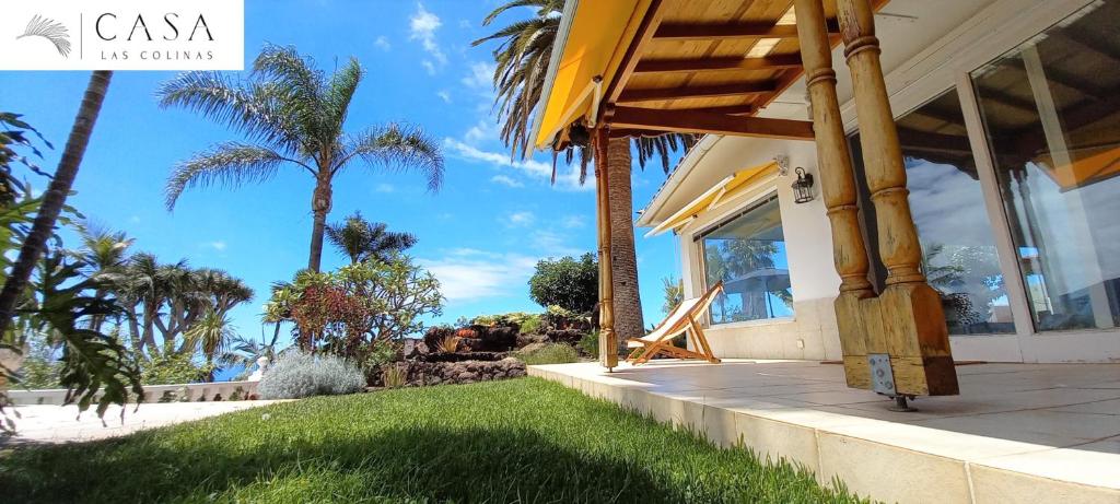 a house with a porch with palm trees in the background at Casa Las Colinas- Preciosa Villa Isleña in La Orotava
