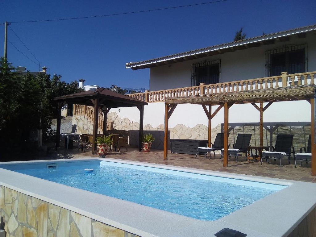 a swimming pool in front of a house at Casa rural CAÑADA PAEZ in Vélez-Málaga