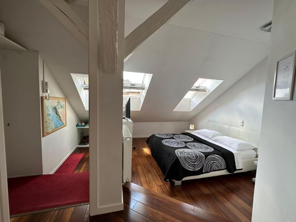 a bedroom with a bed in a attic with skylights at Jacuzzi Apartment - Center Zagreb in Zagreb