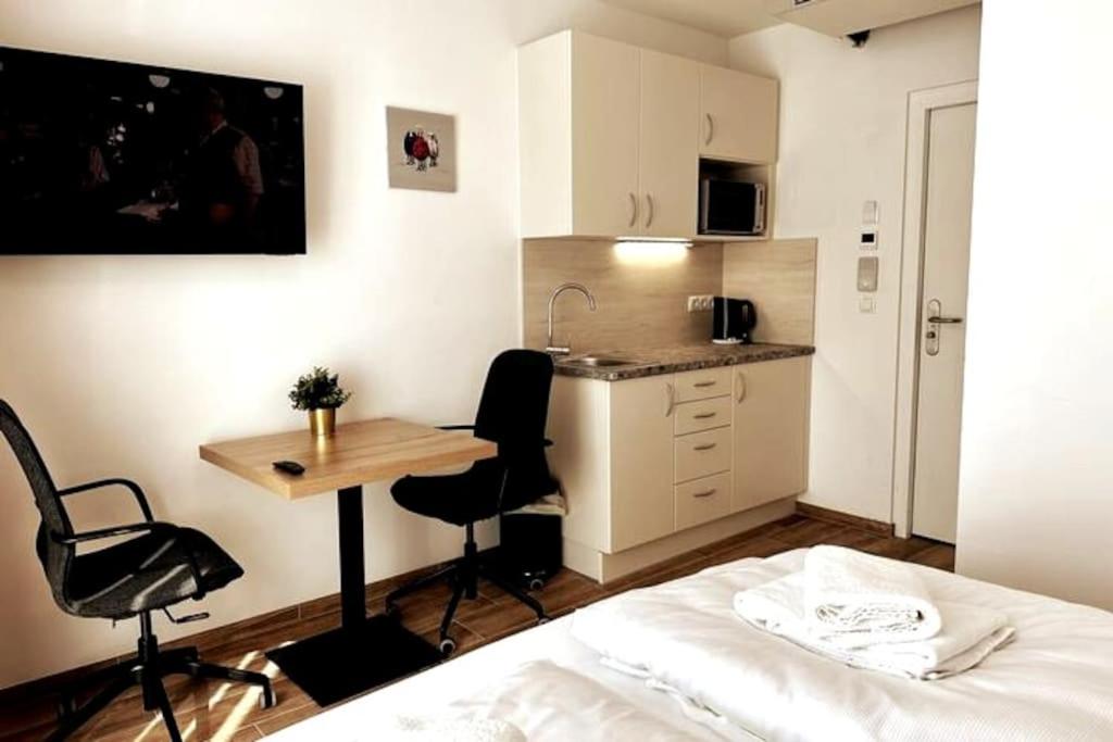 1 dormitorio con cama, escritorio y cocina en AJO Vetmed en Viena