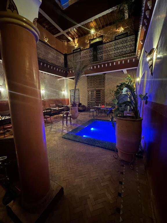 einem Pool in der Mitte eines Zimmers mit einem Gebäude in der Unterkunft Riad Naya in Marrakesch