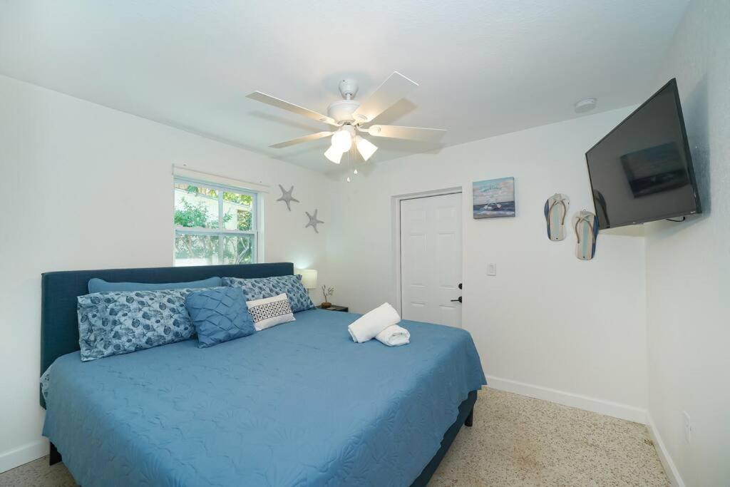 - une chambre avec un lit bleu et un ventilateur de plafond dans l'établissement Modern, Fresh - Only 3 miles to the Beach!, à Sarasota