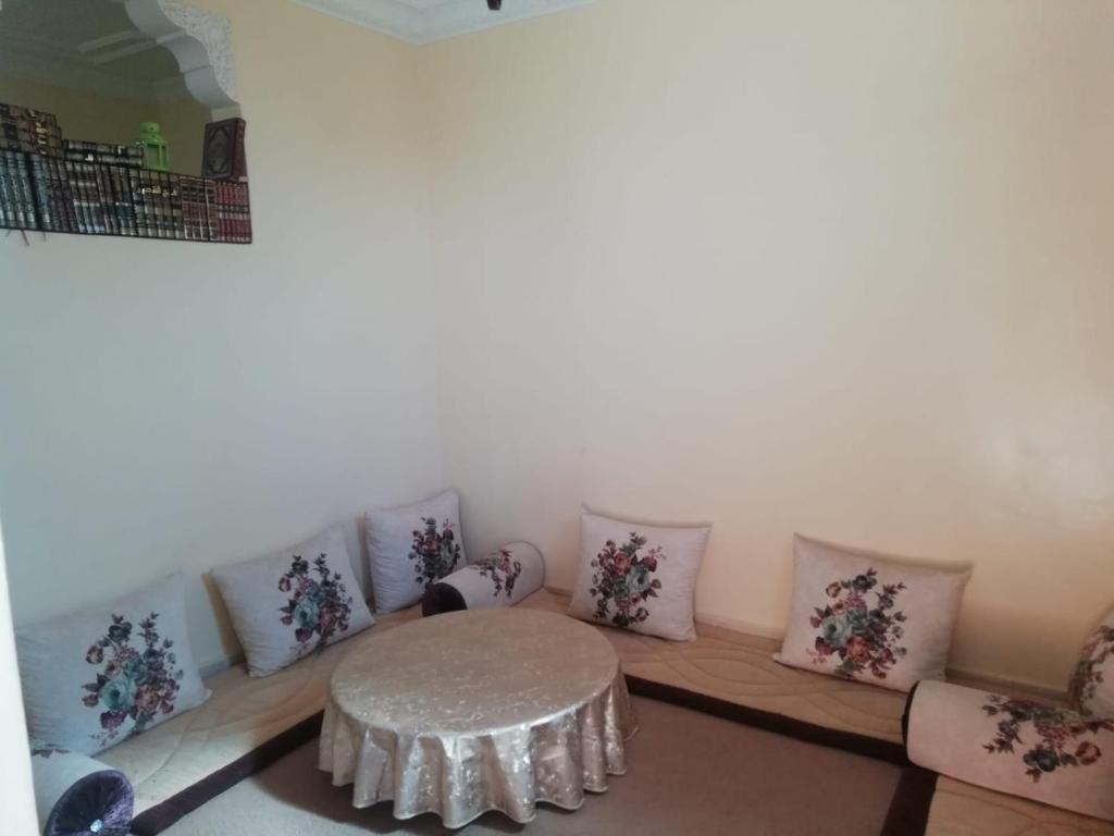 um quarto com uma mesa e um monte de almofadas em شقة بجنب مطار المسيرة 