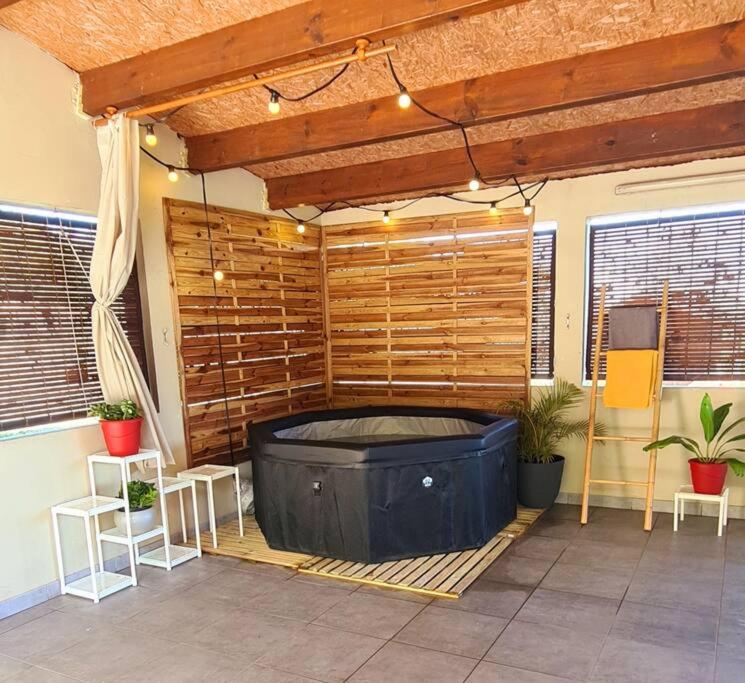 una gran bañera de hidromasaje en un patio con 2 sillas en L'escapade sauvage en Saint-Joseph
