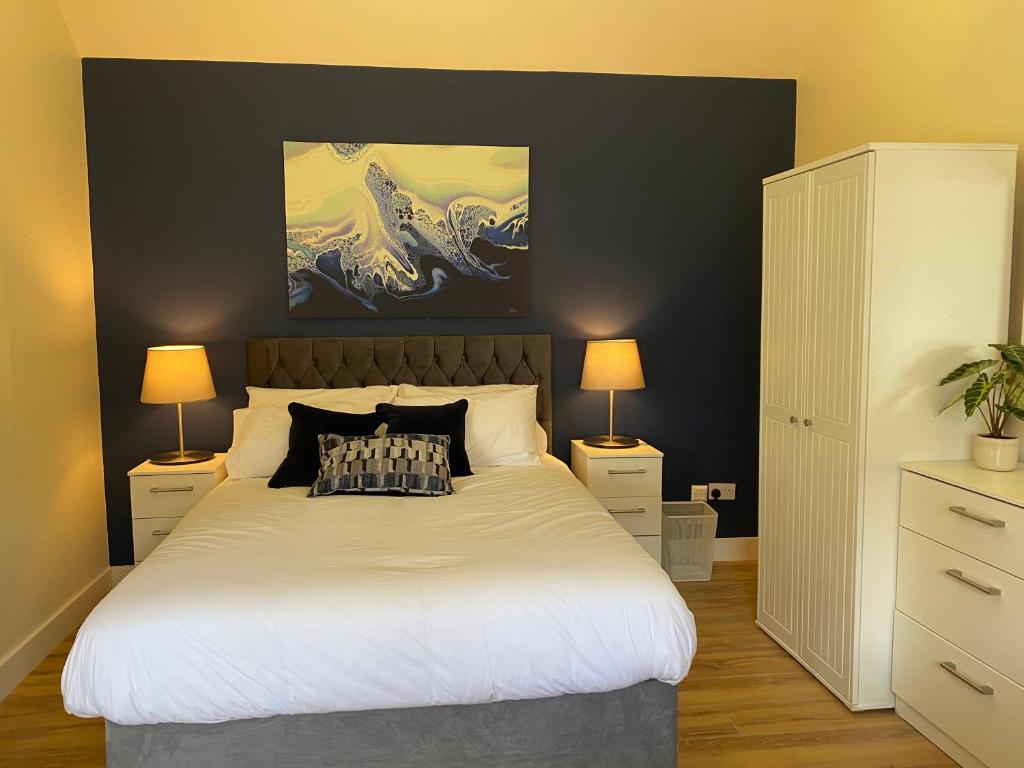 a bedroom with a large white bed with two lamps at Church View House in Kells