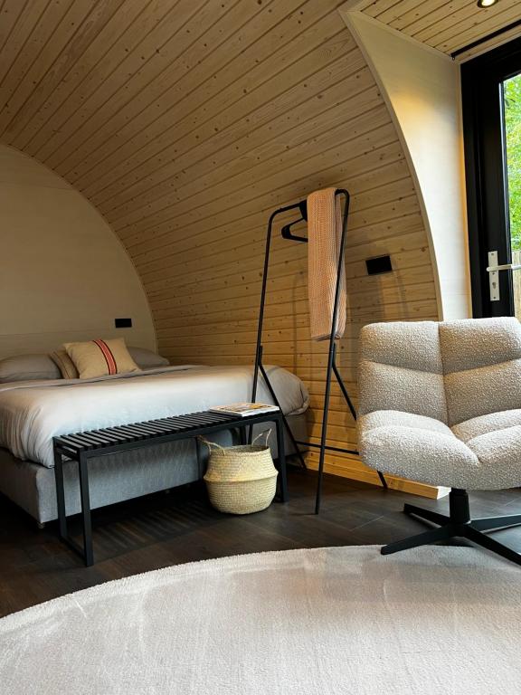een slaapkamer met een bed en een stoel in een kamer bij Bijzonder Lekker overnachten in Beetsterzwaag