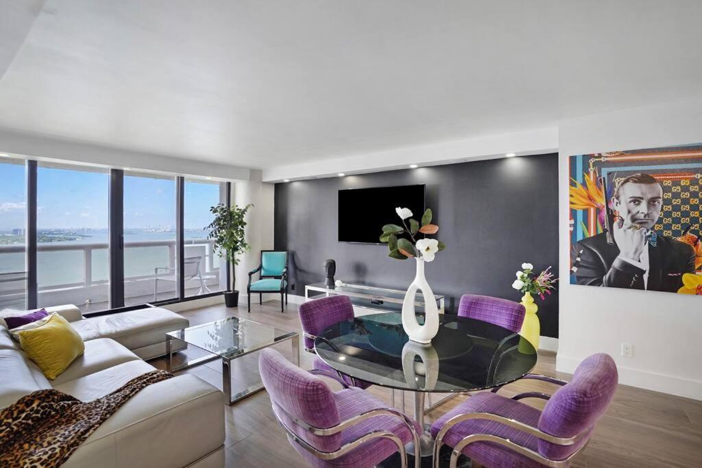 sala de estar con mesa de cristal y sillas moradas en The Bond - OO7 Vibes and Penthouse Water Views!, en Miami