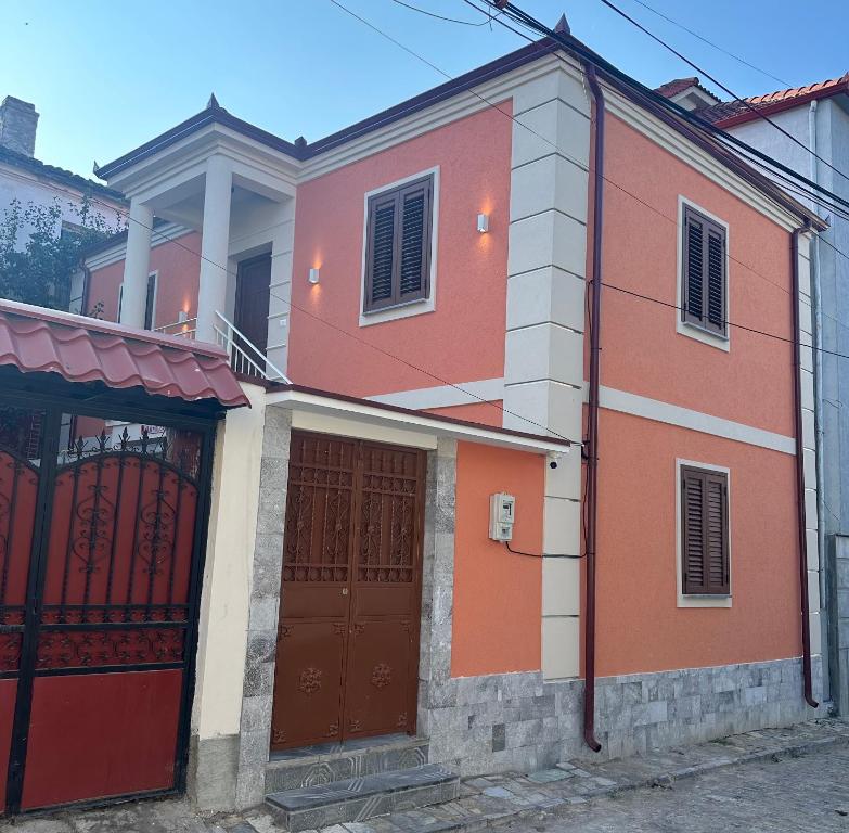 uma casa vermelha e branca com duas portas em Vila Alba em Korçë