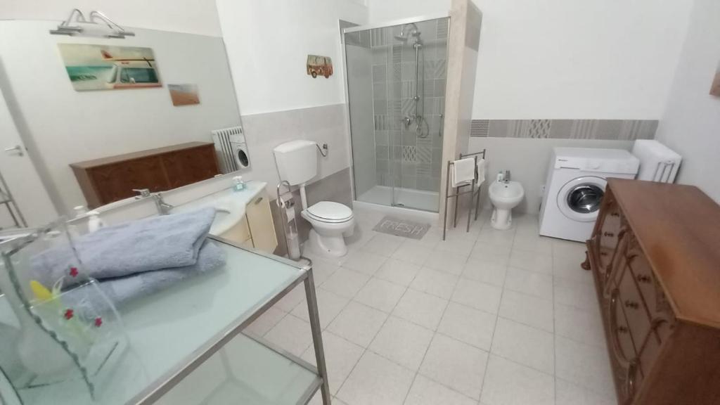 a bathroom with a sink toilet and a washing machine at L'Iris in Livorno