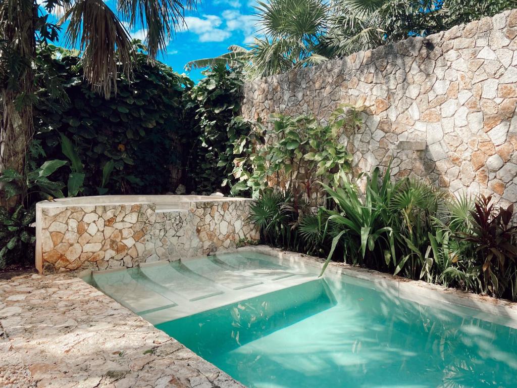 a swimming pool in front of a stone wall at Real Haciendas in Valladolid