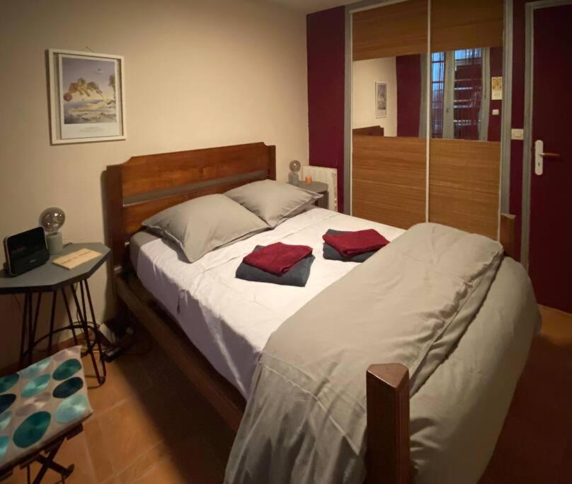 - une chambre avec un lit doté de 2 oreillers rouges dans l'établissement A 150 pas du Capitole!, à Toulouse